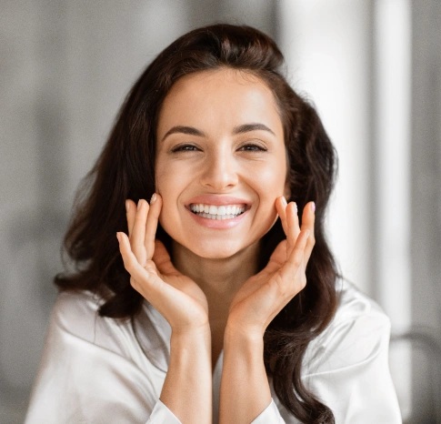 Woman showing bright and natural looking teeth after cosmetic dentistry treatment in Carthage