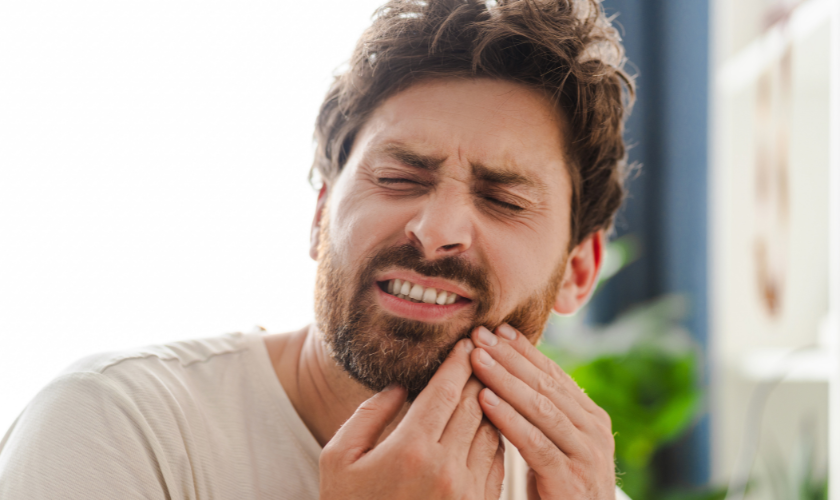 Patient holding their jaw after breaking a tooth and seeking emergency dental care in Plant City FL