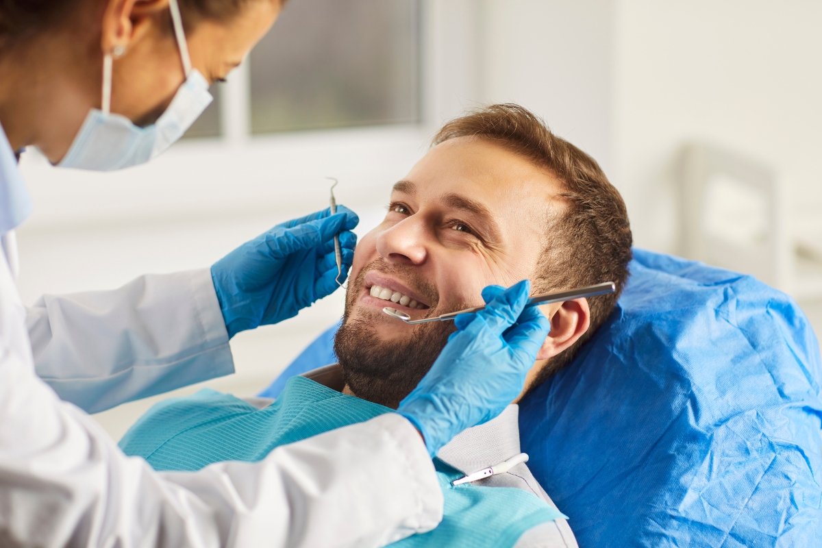 Dentist performing a routine dental exam as part of preventive dental care in Raleigh, NC