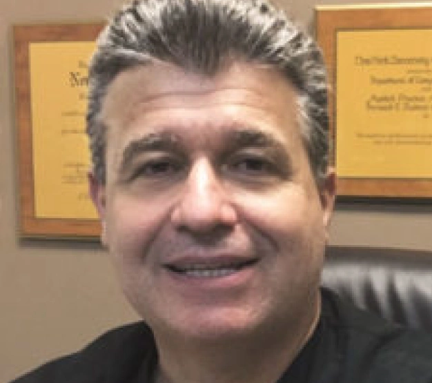 Dr. Gary Salamon, dentist at Clewiston dental practice, smiling in office setting.