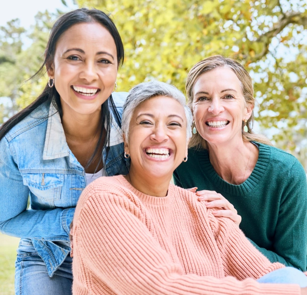 Three smiling women of different ages outdoors in Clewiston, FL.
