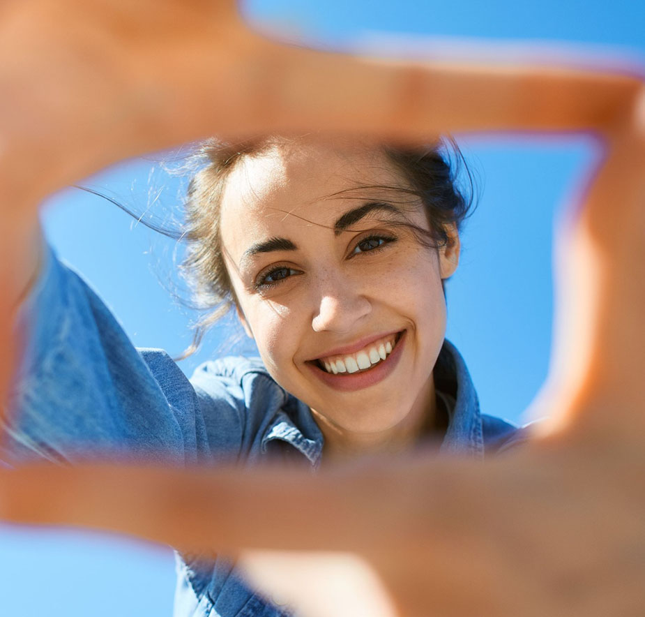 Smiling patient taking a selfie after completing a smile makeover at Hallmark Dental.