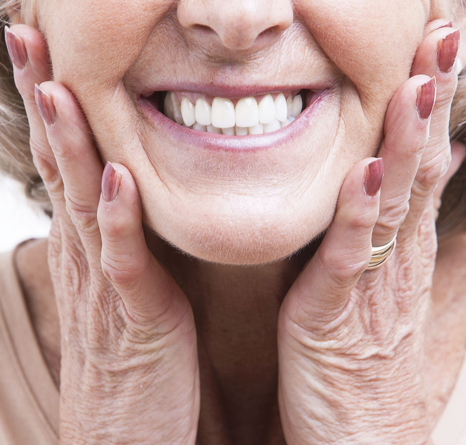 A female patient smiling after the placement of dental dentures.”