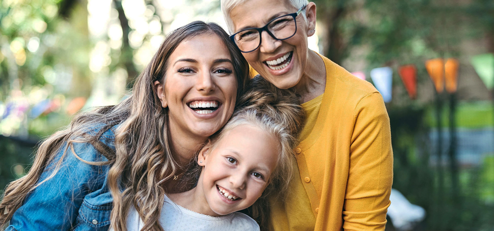 Happy couple with their child smiling after restorative dental care at Hallmark Dental.