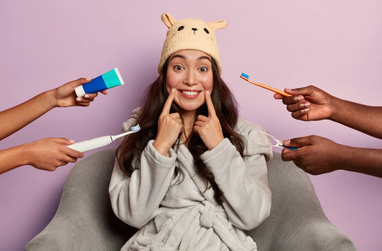 Woman smiling while holding dental care tools, promoting professional teeth whitening at Hapii Dental Austin for a brighter smile in Austin, TX.