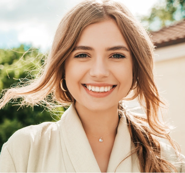 A woman smiling confidently with straight white teeth after receiving cosmetic dentistry Alpharetta services.