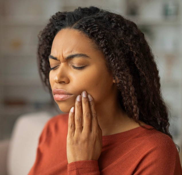 Young woman with tooth pain visiting Lilburn Smile Makers Dental in Lilburn, Georgia for emergency dental care