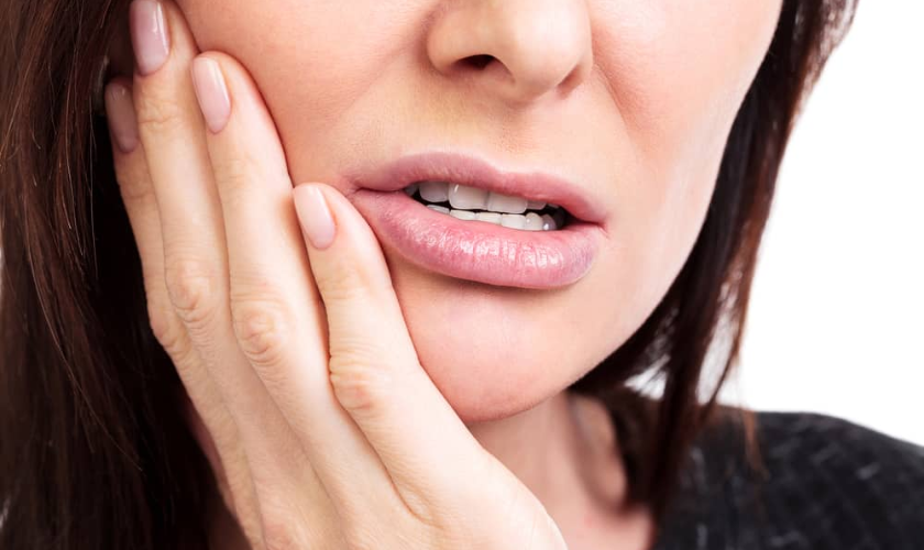 Woman holding her jaw in pain from a dental emergency