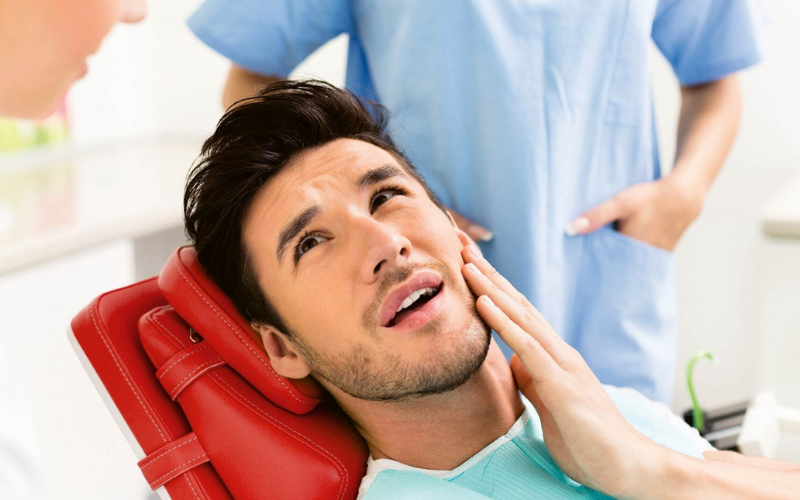 Man holding his jaw in pain from a toothache