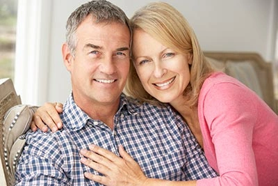 Couple smiling after a holistic restorative dental treatment