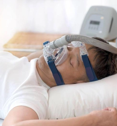 Person sleeping with a CPAP mask on to treat snoring and sleep apnea