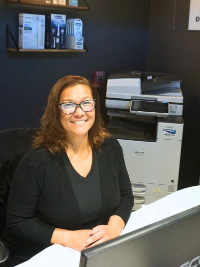 Northwest Natural Dentistry front desk staff member smiling at the insurance and financing desk