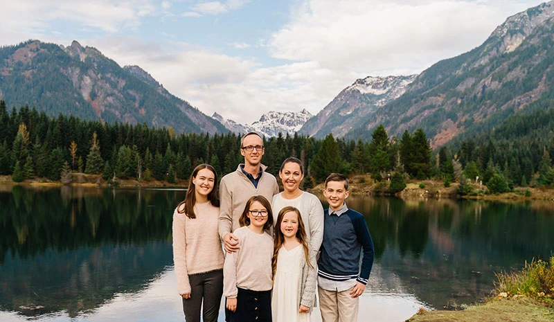 Dr. Cory Harker and his family standing in front of a mountain lake