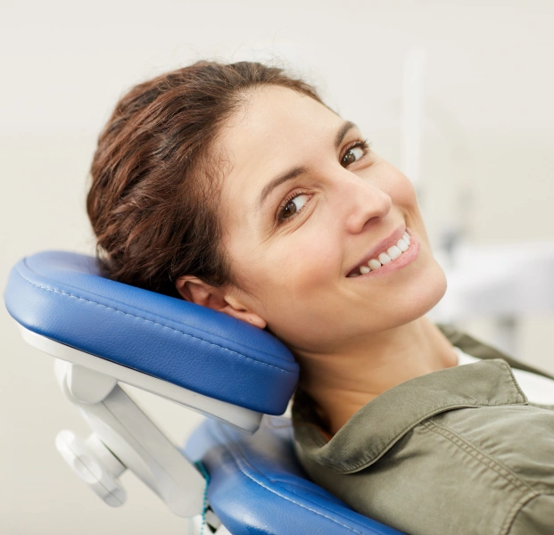 Female patient smiling in dental chair during treatment appointment