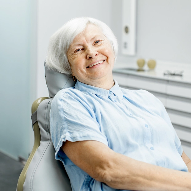 Senior woman smiling warmly after restorative dental treatment