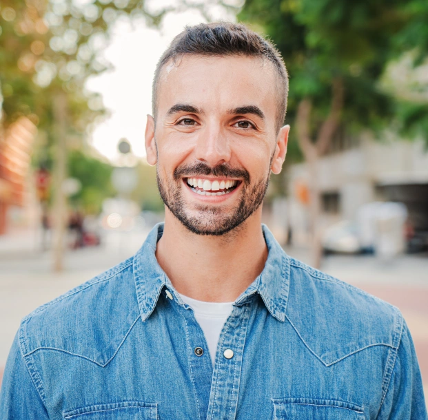 Young man smiling confidently after complete smile makeover results