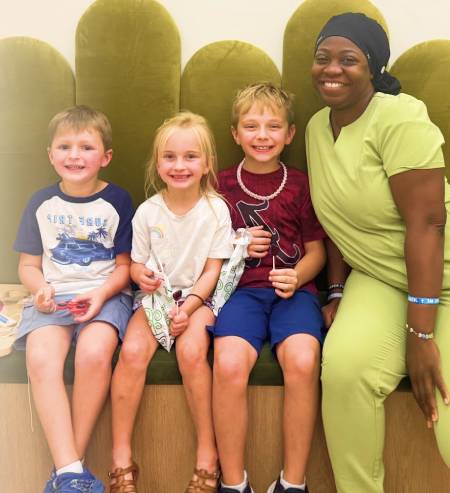 Dr. Simon with happy young patients at Pure Hearts Pediatric Dentistry Charlotte NC