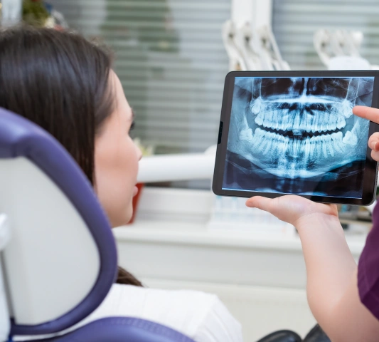 Dr. Purna Patel showing a digital dental X-ray to a patient.