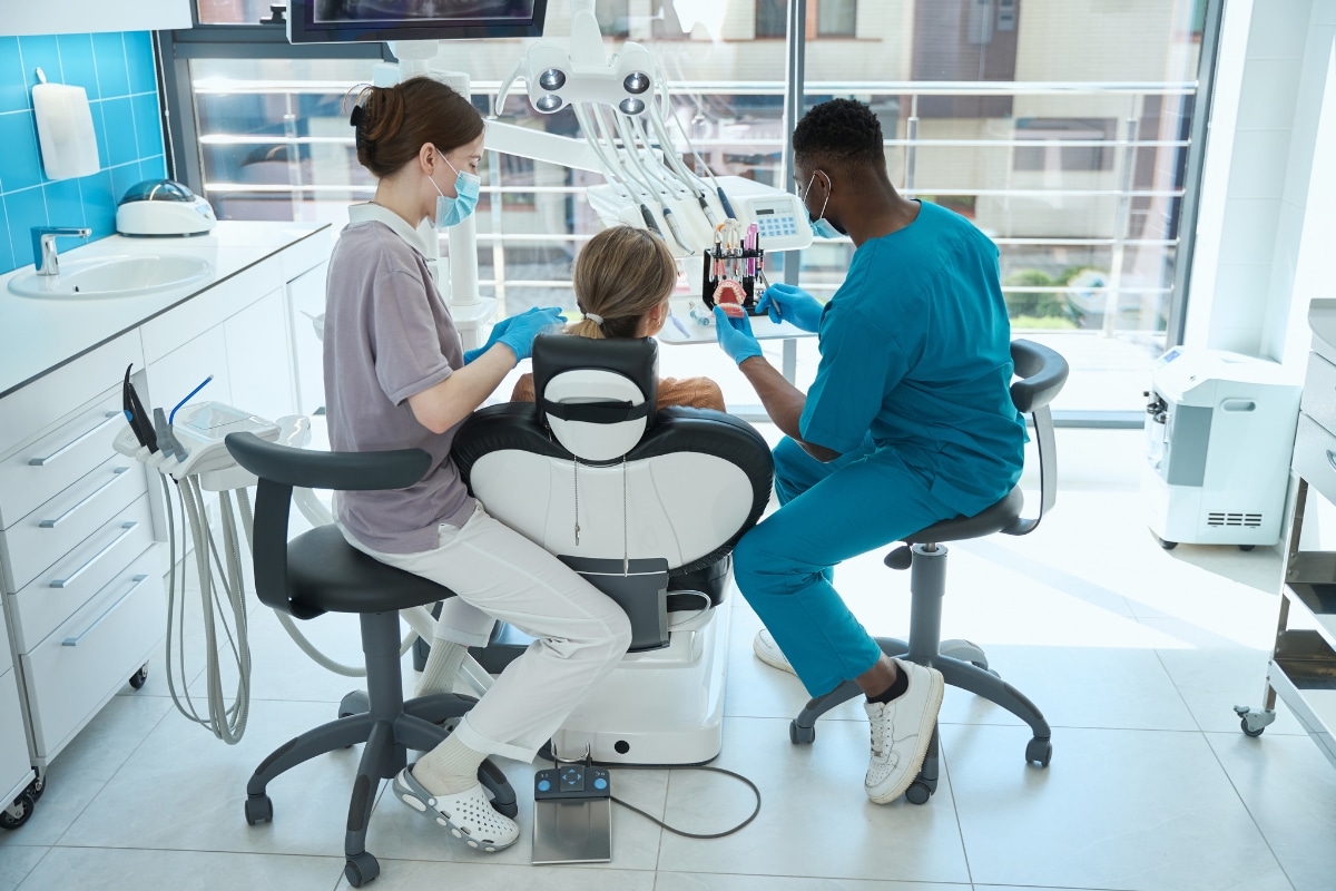 Woman consulting dentist about wisdom tooth extraction in Tomball TX with dental X-ray