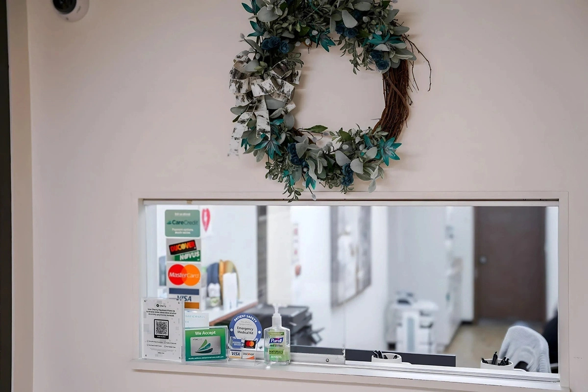 Front desk window with decor and check-in area at Rollstone Family Dental