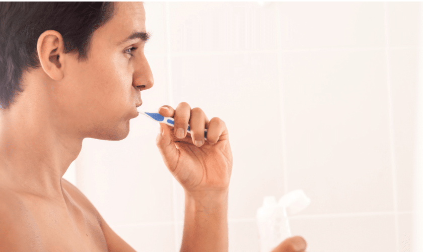 Patient brushing teeth incorrectly while learning proper oral hygiene techniques at a Charlottesville dental office