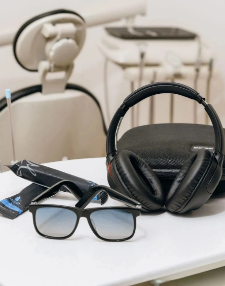 Noise-canceling headphones and blue-tinted sunglasses on dental tray as part of the patient comfort menu at Seven Bridges Dental Studio in Woodridge, IL