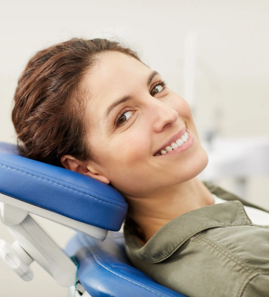 Happy female patient smiling during a dental cleaning and exam appointment