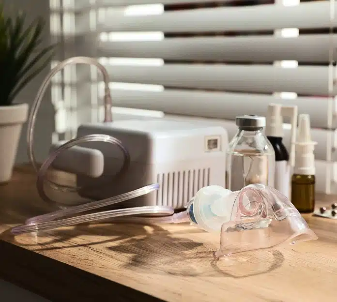CPAP machine with tubing and mask on a wooden nightstand