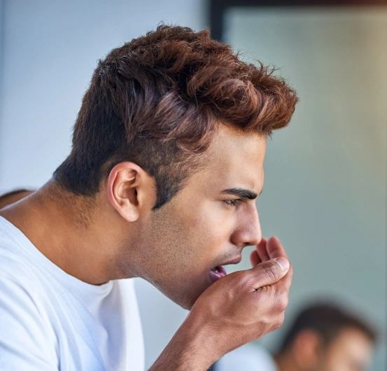 Man covering his mouth due to chronic bad breath before receiving professional halitosis treatment at South Arlington Smiles in Arlington, TX.