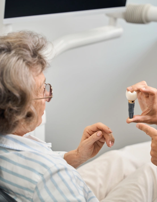 Patient learning about tooth replacement during a free dental implant consultation.