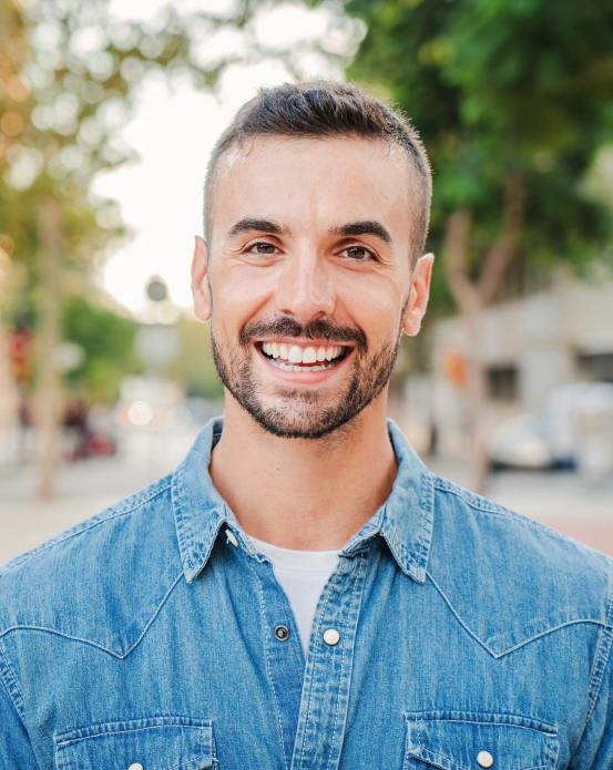 Man smiling confidently with bright, white teeth following a cosmetic teeth whitening procedure in Arlington, TX.