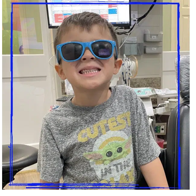 Smiling young patient wearing sunglasses during a pediatric dental visit at Spanaway Children's Dentistry near Eatonville