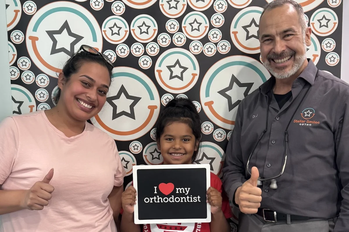 Parents and child smiling together at an orthodontic office