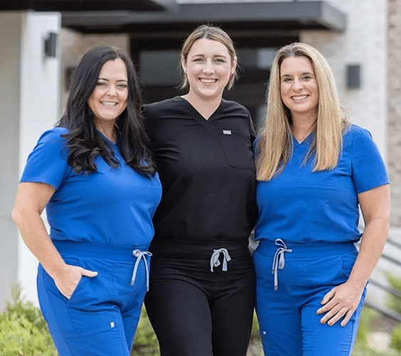 Meet Dr. Rachael Cross, DMD, Auburn dentist, standing with two female dental assistants in front of Thrive Family Dentistry of Auburn