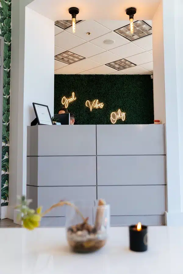 Modern reception area with greenery accent wall at TRU Dentistry SoCo in South Austin, TX