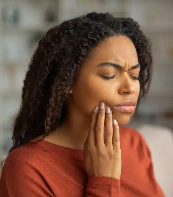Woman experiencing tooth pain in need of emergency dental care at TRU Dentistry SoCo in South Austin, TX