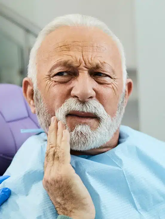 Senior man with tooth pain in need of tooth extraction at TRU Dentistry SoCo in South Austin, TX