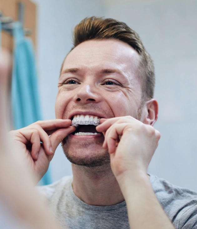 Patient holding a clear aligner tray for invisible teeth straightening in Holland, PA