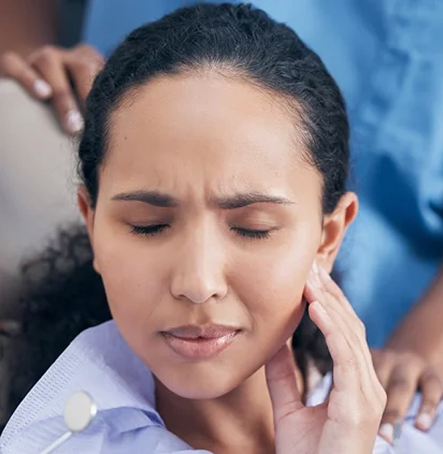Woman holding her jaw in pain seeking emergency dental care for sudden tooth pain
