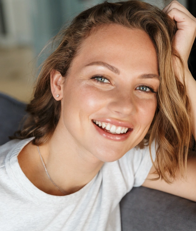 Woman with a radiant white smile showcasing the results of professional teeth whitening treatment
