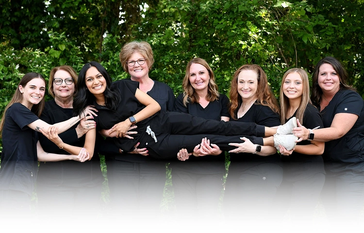 White Rose Dentistry team of eight dental professionals smiling together outdoors in York, SC.