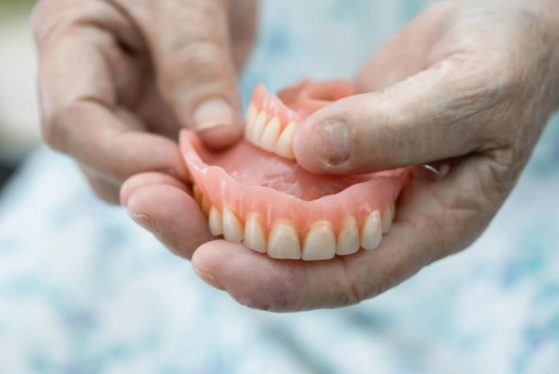 Dentist holding a dental denture at The Woodlands Dentistry and Orthodontics in The Woodlands, TX
