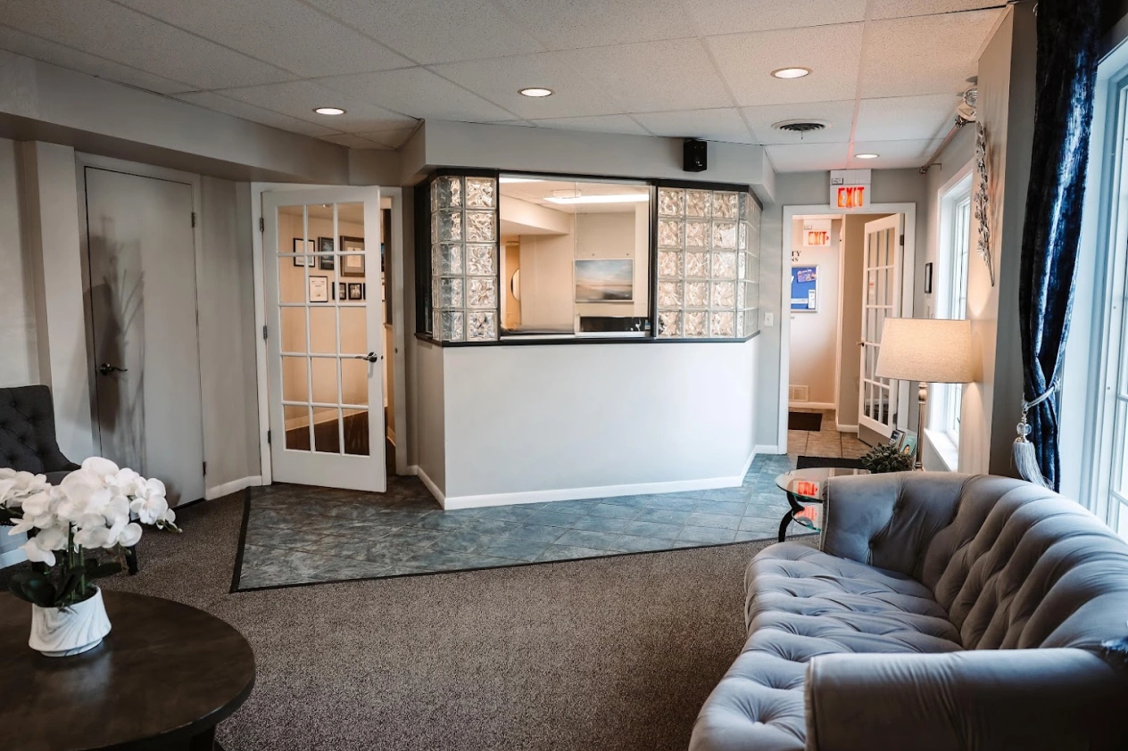 Modern dental practice reception area with comfortable seating and professional check-in desk.
