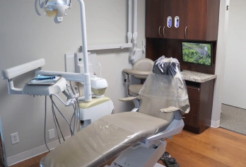 Modern dental treatment room with patient chair, overhead light, and professional equipment at our Aurora practice.