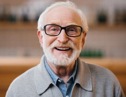 Smiling senior man with glasses in dental office setting for root canal therapy consultation.